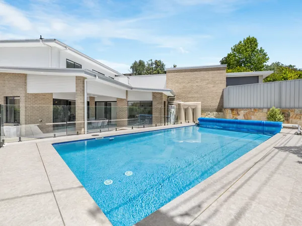 Example photo: a pool beside a two storey house